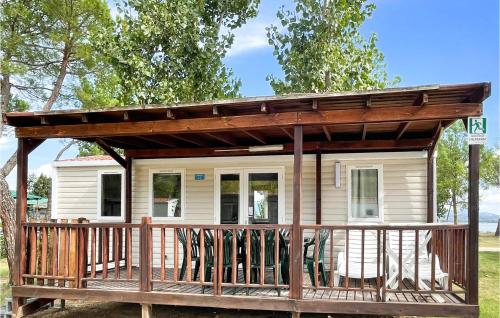 a small white house with a wooden porch at Pet Friendly Stacaravan in Tuoro sul Trasimeno