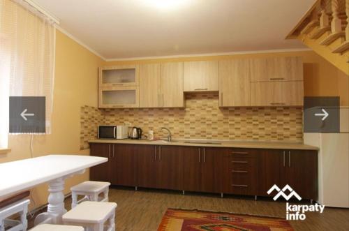 - une cuisine avec des placards en bois et un comptoir dans l'établissement Dva Opryshka, à Yaremtche