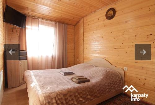 - une chambre avec un lit dans une pièce en bois dans l'établissement Dva Opryshka, à Yaremtche