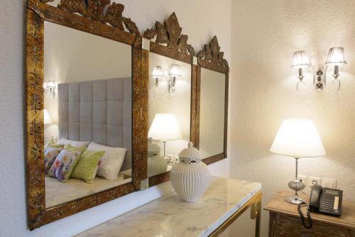 a bedroom with a mirror and a vase on a counter at Leandros Hotel in Nea Roda
