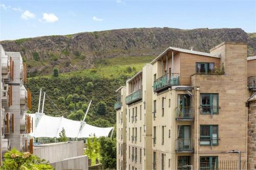 an apartment building with a mountain in the background at EDI b&b in Edinburgh