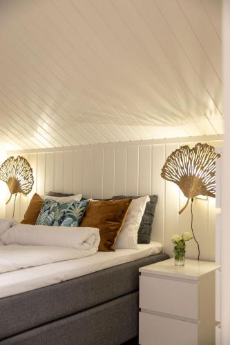 a bedroom with a bed with white walls and two lamps at Vollsnes Feriehus in Hjelle