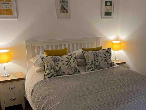 a bedroom with a bed with pillows and two lamps at No5 at 53 - 2 bed apartment in Leek, Staffs Peak District in Leek