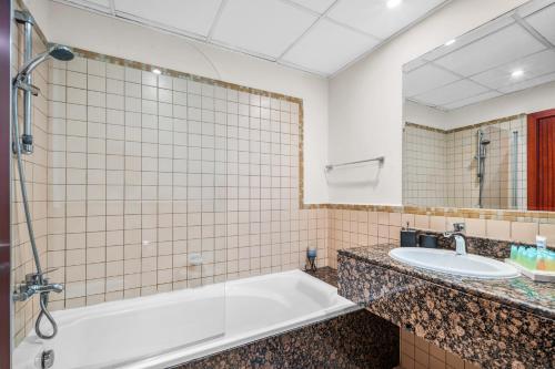 y baño con bañera y lavamanos. en Lovely 2-bed condo in JBR - 5 mins from beach - Palm View! en Dubái