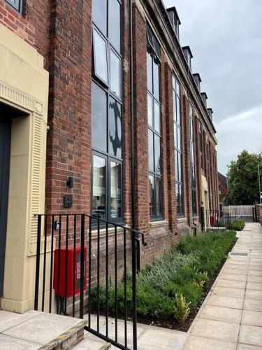 a brick building with a gate in front of it at No5 at 53 - 2 bed apartment in Leek, Staffs Peak District in Leek