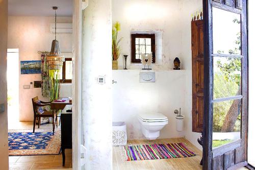 a bathroom with a toilet and a dining room at Hideaway Ibiza Villa Hilltop Estate Can Arte 6 Bedrooms I Santa Eulalia in Santa Eularia des Riu