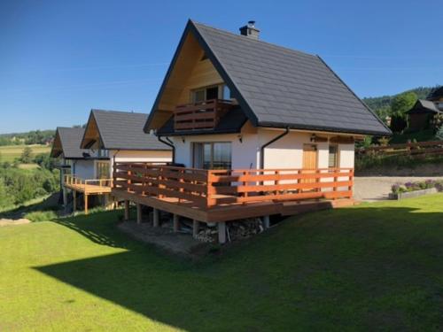 a large house with a large deck on a lawn at DOM u WIECHA in Huba