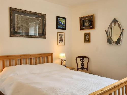 a bedroom with a bed and some pictures on the wall at Whiteadder Cottage in Spittal