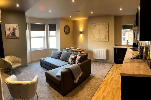 a large living room with a couch and a kitchen at Spacious 3BR Duplex near Loughborough University Sleeps 6 in Loughborough