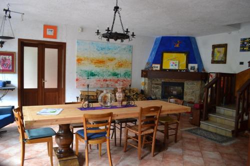 comedor con mesa de madera y chimenea en Casa di Montagna San Colombano, en San Colombano