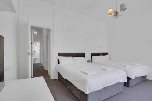 Un pat sau paturi într-o cameră la Hamilton Apartments hosted by Maysa London