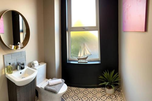 a bathroom with a sink and a window with a sailboat on it at University Duplex • Sleeps 6 in Loughborough