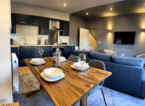 a dining room and kitchen with a wooden table at Spacious 3BR Duplex near Loughborough University Sleeps 6 in Loughborough