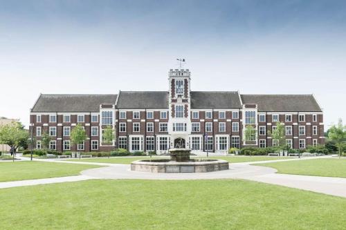 a large brick building with a fountain in front of it at Spacious 3BR Duplex near Loughborough University Sleeps 6 in Loughborough