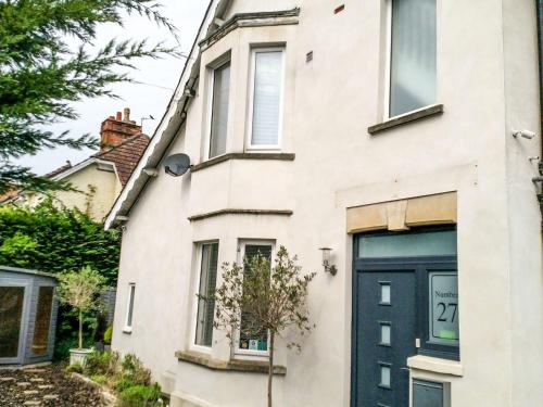 a white house with a blue door at Tree of Life House, Number 27 Bere Lane in Glastonbury