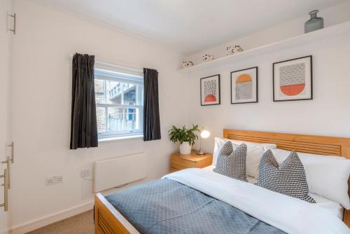 een slaapkamer met een bed en een raam bij Penthouse Kings Cross in Londen