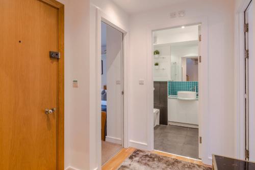 een hal met een deur en een badkamer met een wastafel bij Penthouse Kings Cross in Londen