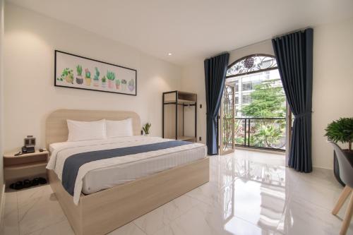 ein Schlafzimmer mit einem Bett und einem großen Fenster in der Unterkunft Bin Bin Hotel 8 - Near Sunrise City in Ho-Chi-Minh-Stadt