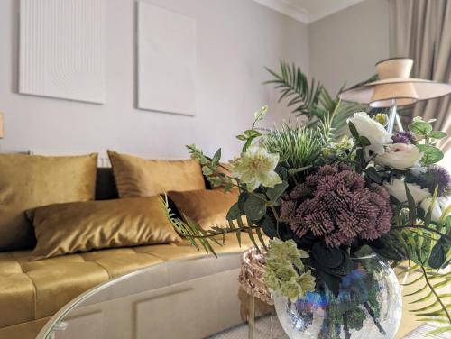 salon z kanapą i wazonem pełnym kwiatów w obiekcie 1BD apartment with balcony in Hoxton - Zone 1 w Londynie