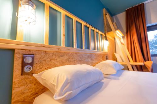 a bedroom with a bed with white sheets and a speaker at Birgit Hôtel Le Havre Centre in Le Havre