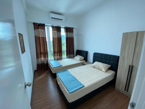 1 dormitorio con 2 camas en una habitación con ventanas en Homestay Sandakan CLL en Sandakan