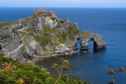 a house on top of a rocky island in the ocean at Maison Muruzabal Etxea in Espelette