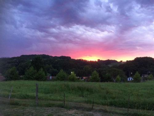 a sunset in a field with a fence in a field at Maison Muruzabal Etxea in Espelette