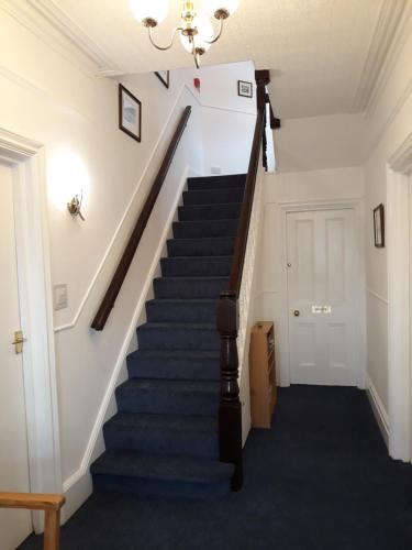 a stairway in a home with a white wall at Montrose Guest House in Minehead