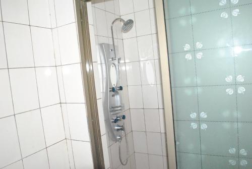 y baño con ducha con cabezal de ducha. en Kiriri Residence Hotel en Buyumbura