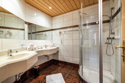 a bathroom with two sinks and a shower at Hotel Breitlehenalm in Obertauern