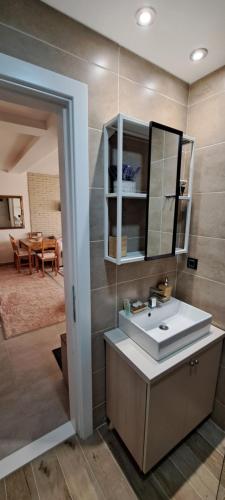 ein Bad mit einem Waschbecken und einem Spiegel in der Unterkunft Apartman N101, Milmari, Kopaonik in Kopaonik