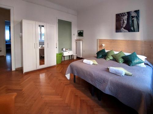 ein Schlafzimmer mit einem großen Bett mit grünen Kissen in der Unterkunft Bed & Chic bed & breakfast in Triest