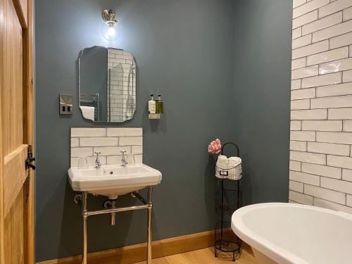 a bathroom with a sink and a tub and a mirror at The Granary - Uk40457 in Newsham