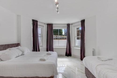 Giường trong phòng chung tại Hamilton Apartments hosted by Maysa London