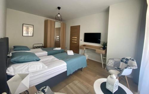 1 dormitorio con 2 camas, escritorio y TV en Wrocław Premium Apartment 4You, en Wroclaw