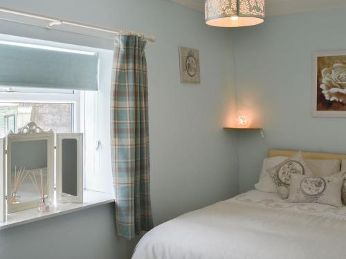 sypialnia z łóżkiem i oknem w obiekcie The Butts Cottage w mieście Stanhope