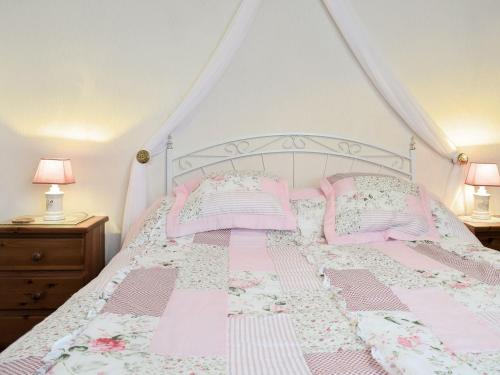 Tynlon Villa في Bronant: سرير وردي مع ملاءات ووسائد وردية وبيضاء