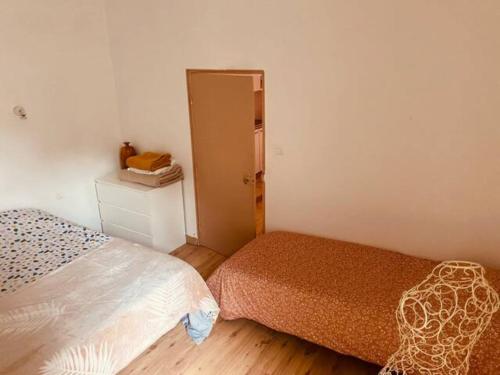 - une petite chambre avec 2 lits et une porte dans l'établissement Coquet studio coeur de ville au calme, à Millau