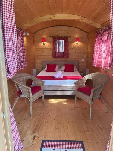 - une chambre avec un lit et deux chaises dans une cabine dans l'établissement Camping La Capelle, à Saint-Martin-Lalande