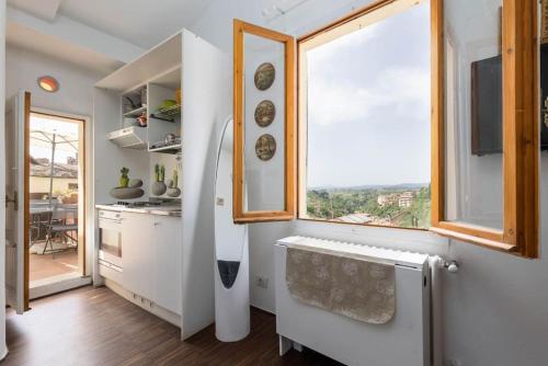 a kitchen with white cabinets and a window with a view at Panoramic lovely time in Siena