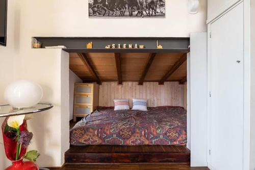 a bedroom with a bed with a wooden ceiling at Panoramic lovely time in Siena