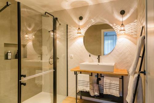 a bathroom with a shower and a sink and a mirror at Casa con piscina en el corazón de Cantabria. in Cos