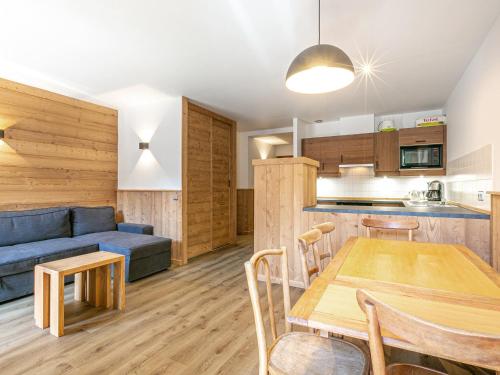 - une cuisine et un salon avec un canapé bleu et une table dans l'établissement Appartement cosy, 2 chambres, centre village, proche pistes, parking, wifi, balcon, animaux sur demande - FR-1-437-25, à La Clusaz