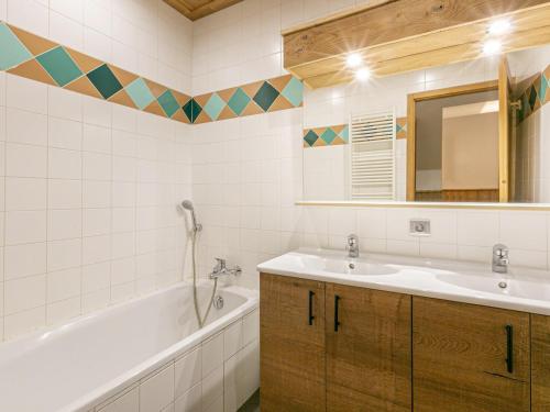 une salle de bain avec un lavabo, une baignoire et un miroir dans l'établissement Appartement cosy, 2 chambres, centre village, proche pistes, parking, wifi, balcon, animaux sur demande - FR-1-437-25, à La Clusaz