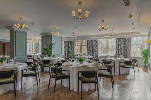 a dining room with white tables and chairs at The Queens Hotel in Portsmouth