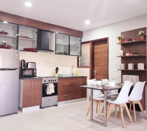 uma cozinha com uma mesa e cadeiras e um frigorífico em Modern 1-bed Seaside Flat Bijilo em Sere Kunda