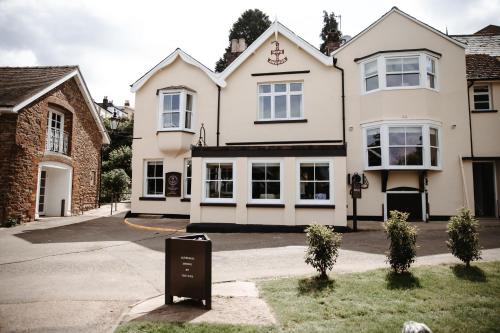 una casa blanca con un cartel delante en The Hope & Anchor Restaurant & Rooms en Ross on Wye