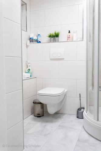 a white bathroom with a toilet and a shower at Ferienwohnung Schröder in Barntrup