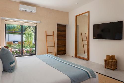 a bedroom with a large bed and a large window at Illa Cozumel in Cozumel