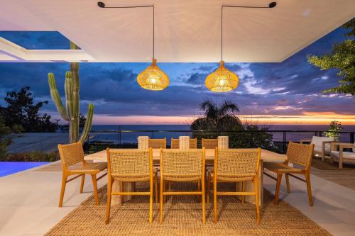 Akwa Resorts Ocean View في شاطئ سانتا تيريزا: طاولة طعام وكراسي مطلة على المحيط